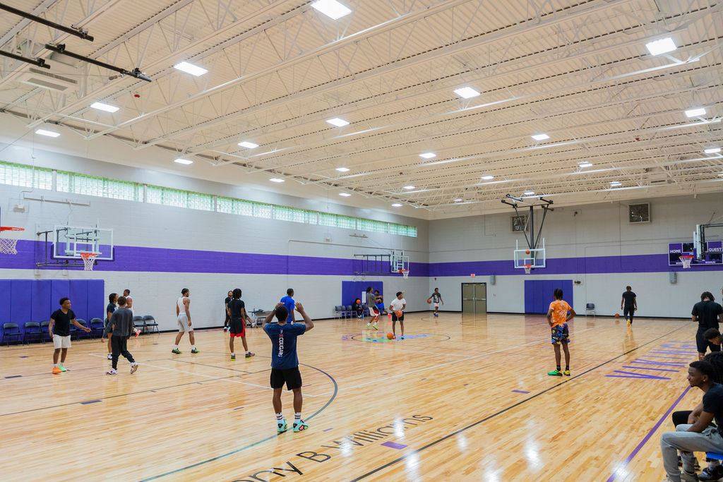 A-group-of-people-playing-basketball-in-an-indoor-court-with-purple-and-white-walls